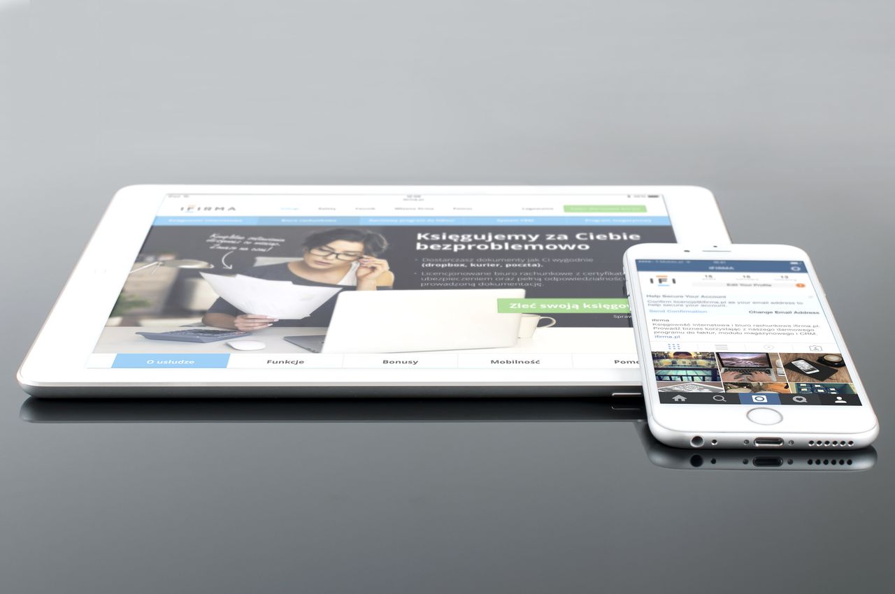 gallery-05 Modern tablet and smartphone displaying web content on a reflective surface, highlighting technology and connectivity.